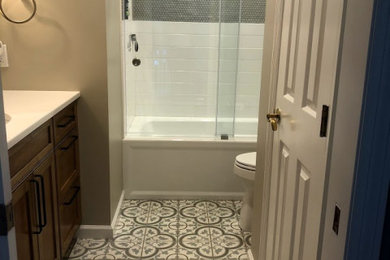 Bathroom - small farmhouse kids' white tile and subway tile cement tile floor, multicolored floor and single-sink bathroom idea in Baltimore with recessed-panel cabinets, medium tone wood cabinets, a one-piece toilet, gray walls, an undermount sink, quartz countertops, white countertops, a niche and a built-in vanity