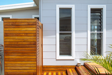 This is an example of a beach style one-storey exterior in Central Coast with wood siding.