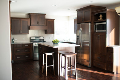 Eat-in kitchen - craftsman u-shaped eat-in kitchen idea in Minneapolis with a drop-in sink, shaker cabinets, dark wood cabinets, laminate countertops, beige backsplash, subway tile backsplash and stainless steel appliances