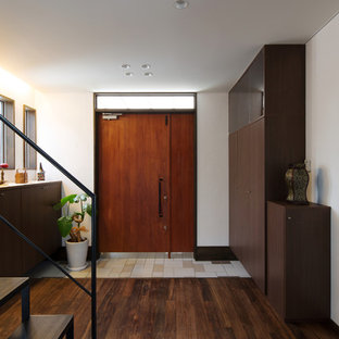 他の地域の片開きドアアジアンスタイルのおしゃれな玄関 (白い壁、濃色無垢フローリング、木目調のドア、茶色い床) の写真