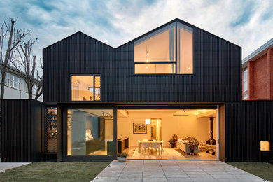 Large contemporary two-storey black house exterior in Melbourne with a gable roof.