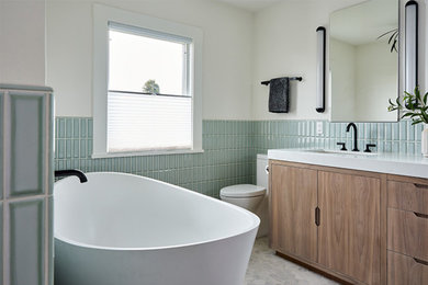 Large transitional master green tile and ceramic tile porcelain tile, gray floor and double-sink bathroom photo in San Francisco with flat-panel cabinets, medium tone wood cabinets, a one-piece toilet, green walls, an undermount sink, quartz countertops, a hinged shower door, white countertops and a built-in vanity