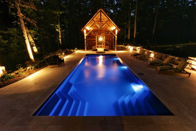 Inspiration for a large timeless backyard stone and rectangular pool house remodel in Other