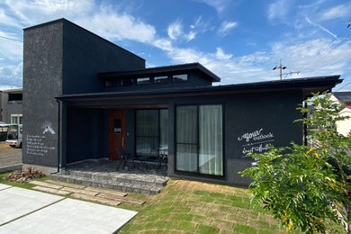 Modelo de fachada de casa negra y negra minimalista pequeña de una planta con ladrillo pintado, tejado de un solo tendido y tejado de metal