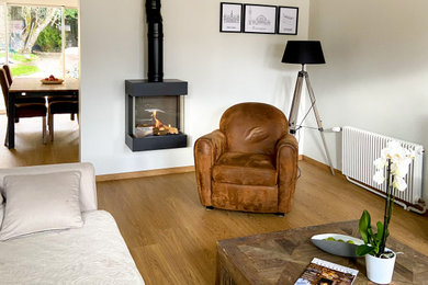 Cette image montre un salon design avec un poêle à bois et un manteau de cheminée en métal.