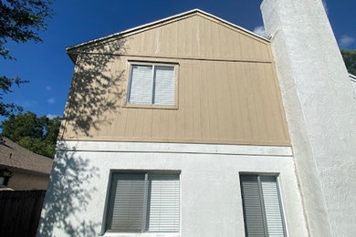Ejemplo de fachada blanca de tamaño medio con revestimiento de aglomerado de cemento