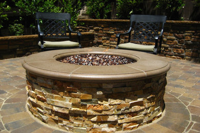 Example of a trendy backyard concrete paver patio design in Los Angeles with a fire pit