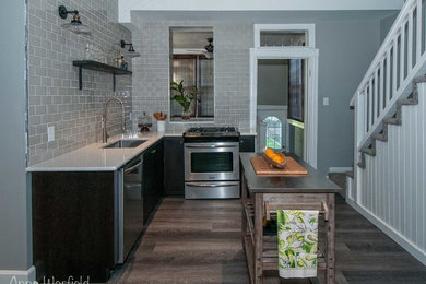 Small mountain style l-shaped vinyl floor kitchen photo in St Louis with a single-bowl sink, flat-panel cabinets, dark wood cabinets, quartz countertops, gray backsplash, subway tile backsplash and stainless steel appliances
