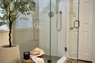Mid-sized eclectic master white tile and porcelain tile vinyl floor, brown floor and double-sink corner shower photo in Austin with shaker cabinets, medium tone wood cabinets, beige walls, an undermount sink, quartz countertops, a hinged shower door, white countertops, a niche and a built-in vanity