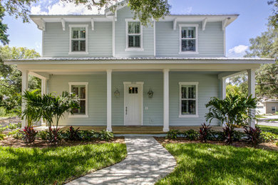 Large beach style blue two-story wood exterior home photo in Tampa with a hip roof