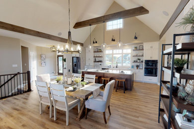 Kitchen - modern laminate floor and brown floor kitchen idea in Milwaukee with white cabinets, quartzite countertops, white backsplash, brick backsplash, stainless steel appliances, an island and white countertops