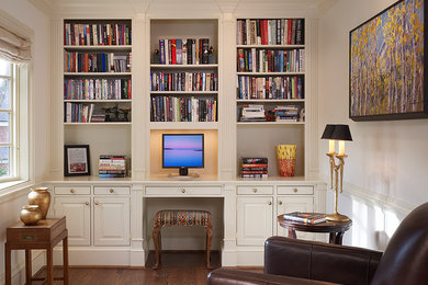 This is an example of a small traditional study room in DC Metro with beige walls, dark hardwood floors, no fireplace and a built-in desk.