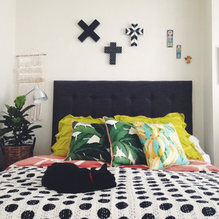 Idée de décoration pour une chambre parentale bohème de taille moyenne avec un mur blanc.