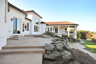 Photo of an expansive mediterranean split-level stucco white house exterior in Sacramento with a hip roof and a tile roof.