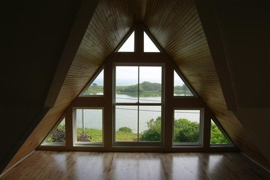 This is an example of a mid-sized contemporary enclosed living room in Portland Maine with light hardwood floors.