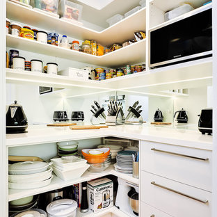 Inspiration pour une arrière-cuisine design avec un placard sans porte, des portes de placard blanches et une crédence en carreau de miroir.