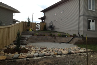 Inspiration for a backyard brick landscaping in Other.