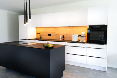 Offene, Einzeilige, Mittelgroße Moderne Küche mit weißen Schränken, Küchenrückwand in Braun, Kücheninsel und schwarzer Arbeitsplatte in Sonstige