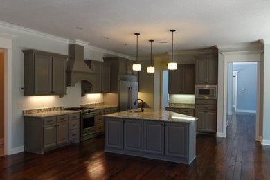 Inspiration for a timeless galley dark wood floor eat-in kitchen remodel in New Orleans with raised-panel cabinets, gray cabinets, granite countertops, stainless steel appliances and an island