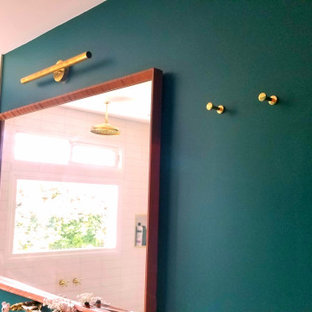 Design ideas for a mid-sized midcentury master bathroom in Los Angeles with raised-panel cabinets, brown cabinets, a freestanding tub, a double shower, a one-piece toilet, white tile, ceramic tile, green walls, porcelain floors, a drop-in sink, wood benchtops, black floor, a sliding shower screen and brown benchtops.