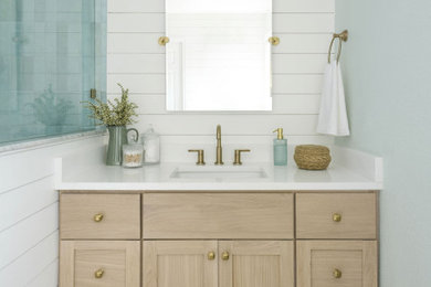 Example of a mid-sized beach style master blue tile and ceramic tile ceramic tile, white floor, single-sink and shiplap wall bathroom design in Other with shaker cabinets, light wood cabinets, blue walls, an undermount sink, quartz countertops, a hinged shower door, white countertops and a built-in vanity