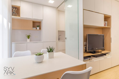 Imagen de salón abierto moderno pequeño con paredes blancas, suelo laminado, pared multimedia y suelo beige