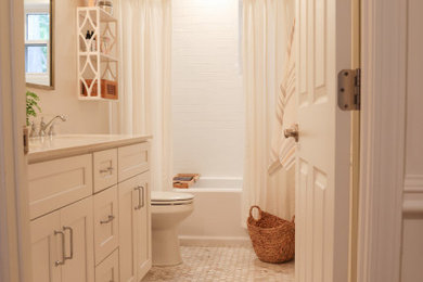 アトランタにあるお手頃価格の中くらいなトラディショナルスタイルのおしゃれな浴室 (シェーカースタイル扉のキャビネット、白いキャビネット、ドロップイン型浴槽、シャワー付き浴槽	、分離型トイレ、白いタイル、セラミックタイル、白い壁、セラミックタイルの床、アンダーカウンター洗面器、クオーツストーンの洗面台、白い床、シャワーカーテン、黄色い洗面カウンター、洗面台2つ、造り付け洗面台) の写真