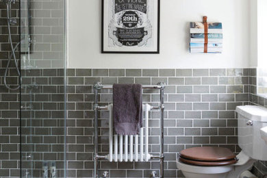 This is an example of a traditional bathroom in West Midlands with a built-in shower, a two-piece toilet, grey tiles, white walls, dark hardwood flooring, brown floors and an open shower.