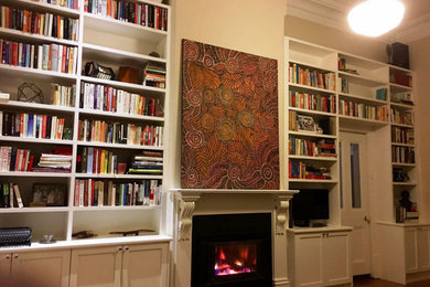 Inspiration for a large traditional open concept family room in Adelaide with a library, white walls, light hardwood floors, a standard fireplace, a metal fireplace surround, a built-in media wall, yellow floor, recessed and decorative wall panelling.