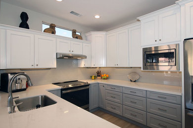 Trendy u-shaped porcelain tile and beige floor open concept kitchen photo in Phoenix with an undermount sink, shaker cabinets, gray cabinets, quartzite countertops, gray backsplash, porcelain backsplash, stainless steel appliances and white countertops