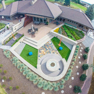 Inspiration pour un xéropaysage arrière design de taille moyenne et l'hiver avec un foyer extérieur, une exposition ensoleillée et des pavés en pierre naturelle.