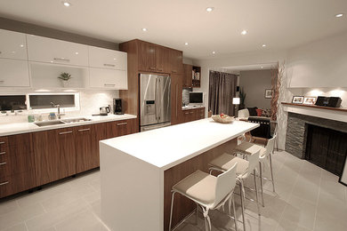 Example of a mid-sized transitional galley ceramic tile eat-in kitchen design in Toronto with a double-bowl sink, flat-panel cabinets, medium tone wood cabinets, solid surface countertops, white backsplash, stone slab backsplash, stainless steel appliances and an island