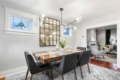 Transitional medium tone wood floor and brown floor enclosed dining room photo in Toronto with gray walls and no fireplace