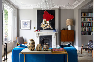 Design ideas for an expansive modern living room in London with light hardwood flooring, a plastered fireplace surround and a chimney breast.