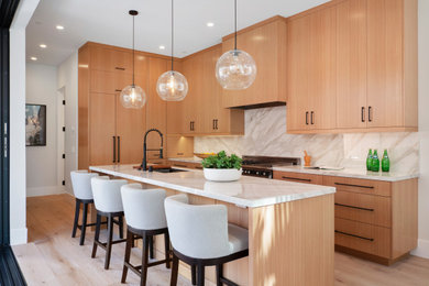 Example of a trendy l-shaped light wood floor and beige floor kitchen design in Orange County with an undermount sink, flat-panel cabinets, medium tone wood cabinets, white backsplash, stainless steel appliances, an island and white countertops