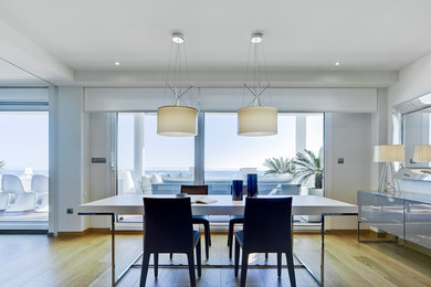 Diseño de comedor contemporáneo grande abierto con paredes blancas y suelo de madera en tonos medios
