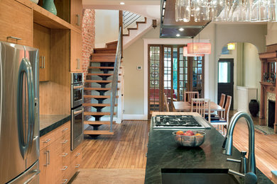Example of a minimalist galley cork floor eat-in kitchen design in DC Metro with a single-bowl sink, stainless steel appliances and an island