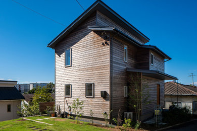 Idée de décoration pour une façade de maison design en bois et bardage à clin avec un toit en appentis et un toit en métal.