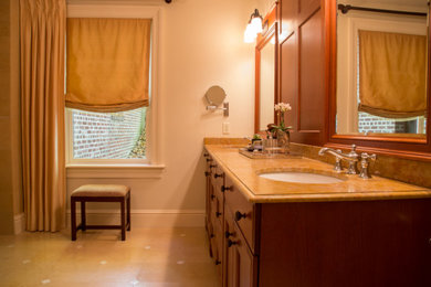 Example of a large master beige tile and limestone tile limestone floor, beige floor and double-sink bathroom design in New York with furniture-like cabinets, medium tone wood cabinets, a bidet, beige walls, a drop-in sink, marble countertops, a hinged shower door, beige countertops and a built-in vanity