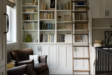 Home office - farmhouse built-in desk dark wood floor, brown floor and exposed beam home office idea in Calgary with beige walls