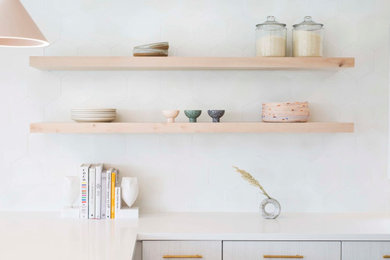 Eat-in kitchen - mid-sized scandinavian u-shaped light wood floor and beige floor eat-in kitchen idea in Los Angeles with an undermount sink, flat-panel cabinets, white cabinets, quartz countertops, white backsplash, stainless steel appliances, an island and white countertops