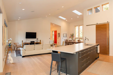 Huge trendy open concept light wood floor living room photo in Portland with white walls and a wall-mounted tv