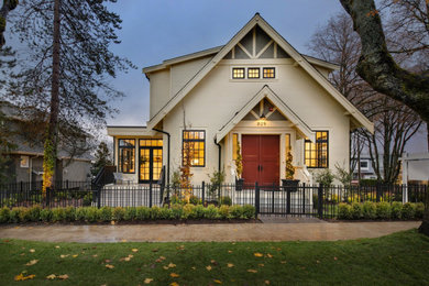 Example of a classic beige exterior home design in Vancouver with a shingle roof and a black roof