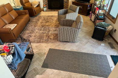 Example of a mid-sized mountain style open concept porcelain tile and beige floor living room design in Kansas City with a standard fireplace and a brick fireplace
