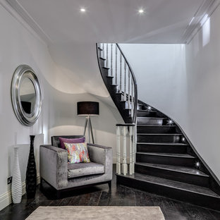 Photo of a contemporary painted wood curved staircase in London with painted wood risers.
