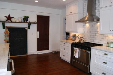 Eat-in kitchen - traditional galley eat-in kitchen idea in Grand Rapids with a farmhouse sink, shaker cabinets, white cabinets, quartz countertops, white backsplash, porcelain backsplash and stainless steel appliances