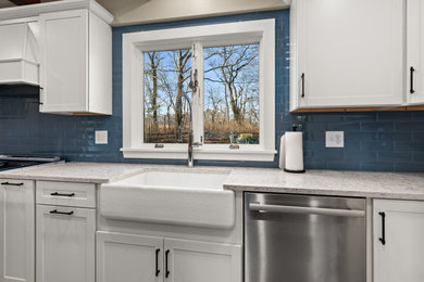 Eat-in kitchen - l-shaped eat-in kitchen idea in Boston with a farmhouse sink, shaker cabinets, blue cabinets, blue backsplash, stainless steel appliances, an island and multicolored countertops