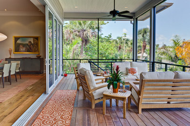 Large transitional backyard deck photo in Miami with a roof extension
