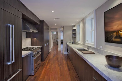 Photo of a mid-sized modern galley kitchen pantry in DC Metro with an undermount sink, flat-panel cabinets, dark wood cabinets, marble benchtops, grey splashback, marble splashback, panelled appliances, medium hardwood floors, no island, brown floor and grey benchtop.