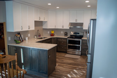 Example of a small trendy l-shaped dark wood floor and gray floor eat-in kitchen design in Omaha with a single-bowl sink, shaker cabinets, gray cabinets, quartz countertops, stainless steel appliances and a peninsula